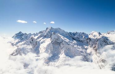 Naklejka premium Mountain range above the clouds and clear sky 
