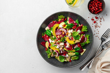 Beetroot salad with avocado, cucumber, feta and pomegranate, seasoned with sesame seeds and flax on...