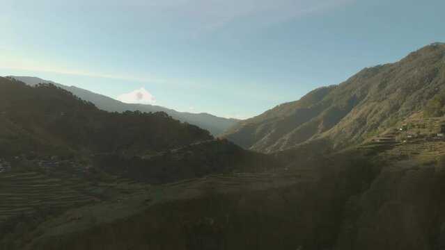 green mountainous valley in remote region of Philippines, Kabayan, Benguet sun appearing onto mountain in distance high aerial wide angle approaching slowly calm relaxing flying god light