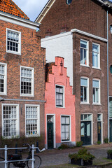 Canal Street view, with narrow pink traditional house and parked bicycle