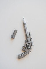 a pen in the form of a pistol lies on a table on a white background.