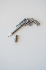a pen in the form of a pistol lies on a table on a white background.