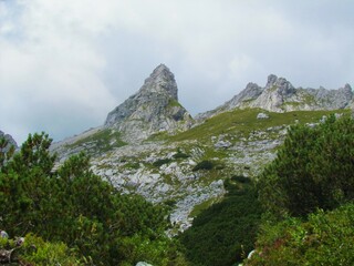 Scenic view of pointy mountain peak above a mountain hut at Zavetišče pod Spickom and alpine landscape bellow