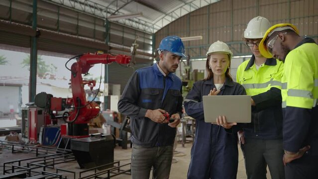 Diversity team of factory engineers ,leadership by engineer women are inspecting and consulting work inside the factory wearing safety clothing according to industrial safety standards.
