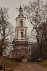Fototapeta na wymiar A tall old bell tower in scaffolding on a hill .