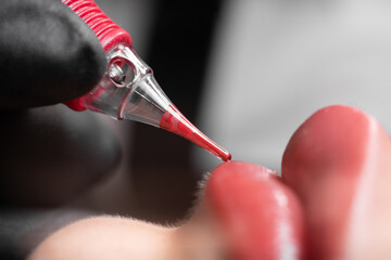 process of applying a permanent makeup tattoo to the lips in a beauty salon, close-up, female lips...