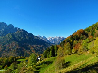 Fototapeta na wymiar Scenic view of the mountains above Kranjska gora in Gorenjska region of Slovenia in the back taken from Srednji vrh with slopes covered in forests with colorful autumn foliage