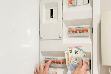 a hand holding euro banknotes turning off power control switch, electricity crisis concept