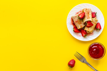 Hot rolled pancakes with strawberry and berry sauce