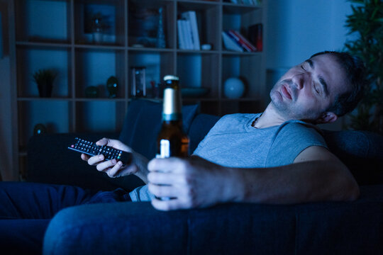 Man Drinking And Sleeping Lying On The Sofa At Home