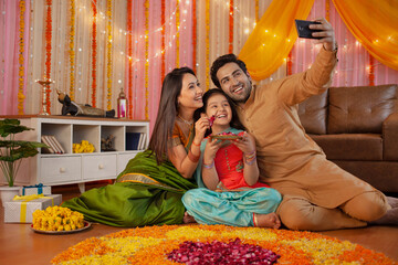 Young Indian couple with their daughter celebrating diwali at home - Indian festival, hindu festival