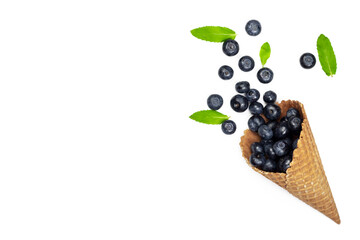Fresh ripe blueberry and mint leaves in waffle cone. Ice cream cone with ripe sweet berries on white background with copy space. Summer creative concept, flat lay, Top view.