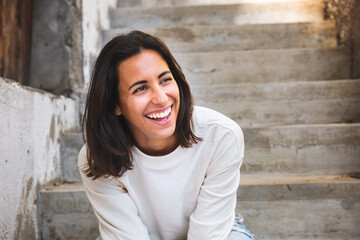 candid portrait happy young latin woman sitting on steps