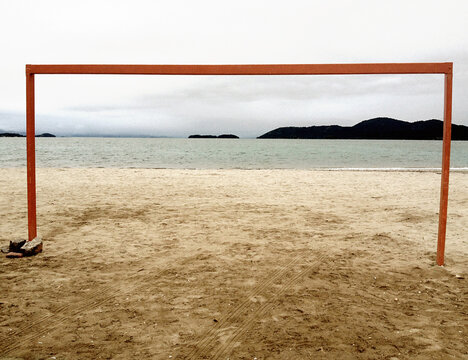A goal on the beach with the sea in the background. Orange beams form a frame in the image. football concept. beach concept.