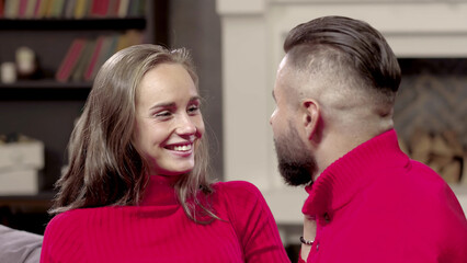 Young couple sitting on couch and talking in living room