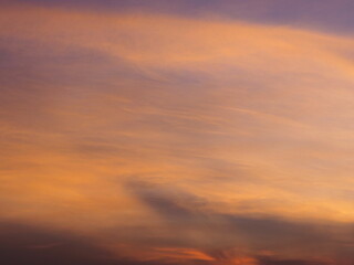 Beautiful pastel orange sky and evening clouds as the sun sets. The twilight sky is beautiful, calm and sweet.

