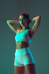Portrait of sportive woman workout, doing exercises with sports equipment isolated on green studio...