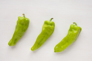 Green raw Cubanelle peppers top view on bright table. Mild pepper.
