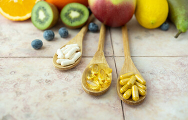 Natural fruits and multivitamin capsules. Natural and synthetic sources of vitamins