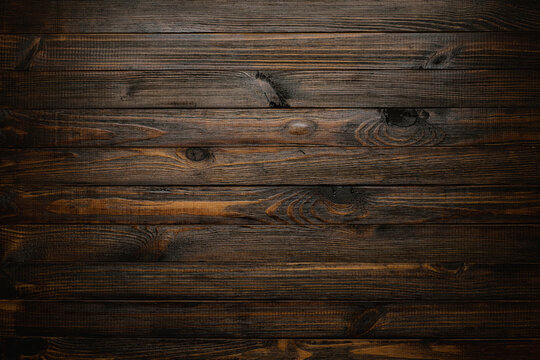 Dark stained wooden table background, rustic wood planks  texture top view.