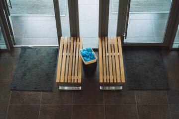 two wooden benches box with blue shoe covers in the lobby of the sports medical center top view