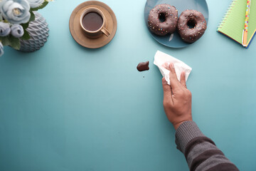 top view of person hand cleaning chocolate spilling with tissue 