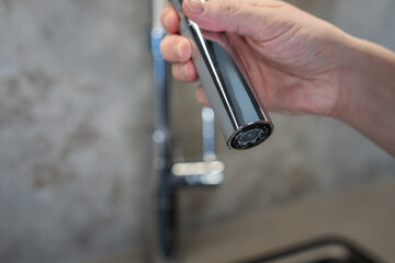 Lime damage chrome on a steel faucet. Women cleaning kitchen, domestic life.