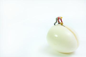 a worker with a chainsaw stands on a boiled egg to cut it in half