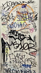 The details of a white wall with different and colorful graffiti