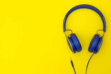 Blue headphones on yellow background