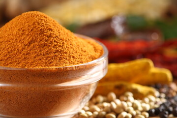 Spicy curry powder in a glass bowl along with all spice ingredients