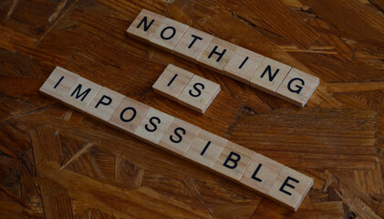 nothing is impossible text on wooden square, motivation and business quote