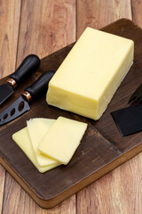 Kashar cheese or kashkaval cheese on wooden background. Sliced Cheddar Cheese