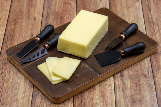 Kashar cheese or kashkaval cheese on wooden background. Sliced Cheddar Cheese