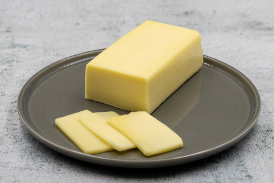 Kashar cheese or kashkaval cheese on stone background. Sliced Cheddar Cheese