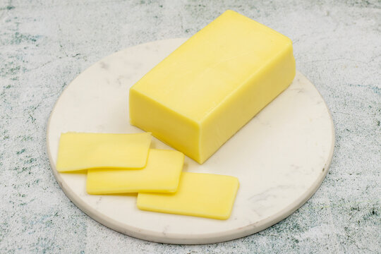Kashar cheese or kashkaval cheese on stone background. Sliced Cheddar Cheese