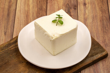 Feta cheese with herbs on wooden background. Close-up breakfast cheese
