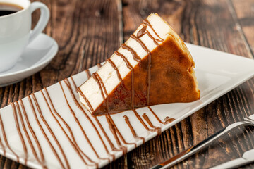 Fototapeta premium Sliced san sebastian cheesecake with coffee on wooden table