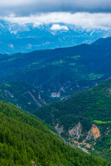 A picturesque vertical landscape view of the French Alps mountains on a cloudy summer day (Valberg, Alpes-Maritimes, France)