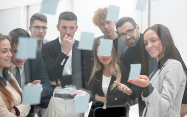 Obraz premium employees discussing sticky notes on the glass