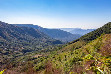 Fototapeta na wymiar mountain range covered with dense green forests and bright blue sky at morning