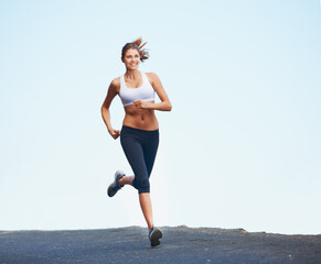 Fototapeta na wymiar Fresh and fit female. Shot of a sporty young woman enjoying a run outdoors.