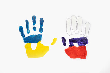 Imprint of child's hands with colors of Ukrainian and Russian flag isolated on white background....
