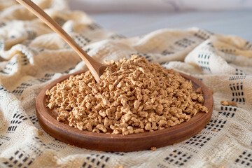 Raw soya chunks, soy meat for vegans in wooden board. Vegan Protein.