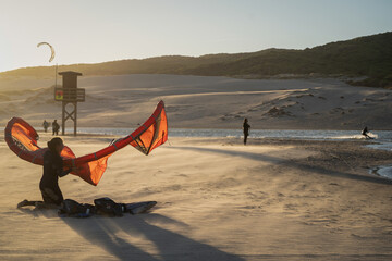 Obraz premium Sunset Kiteboarding Adventure on Windy Beach - Extreme Sports, Freedom, and Outdoor Lifestyle