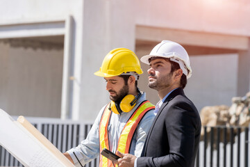 Engineer with business manager are talking in construction site,Project owner with blueprint working to new residential home building work site.