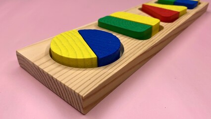 Wooden colorful game with geometric shapes for the development of children in kindergarten