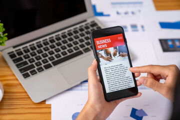 business woman using a mobile phone in the office to update financial investment news and analysis of business stocks via smartphone
