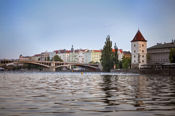 perspective of prague at sunset golden hour from the side of the Vltava River and Malostranska waterworks