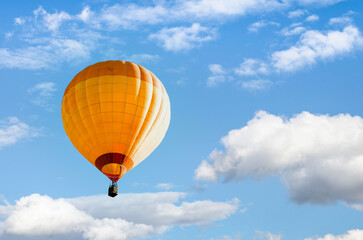 Orange hot air balloon flying over blue sky